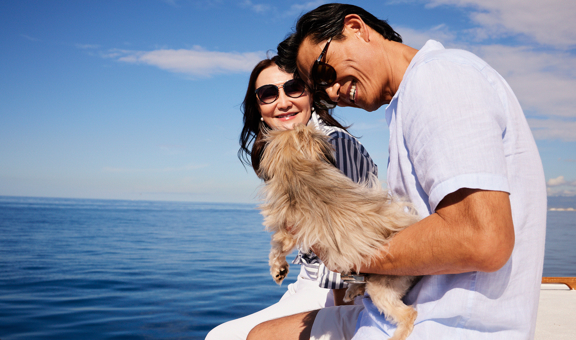 Couple on sailboat with dog