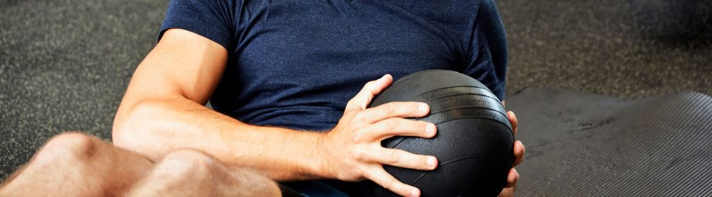 Man exercising with medicine ball at gym